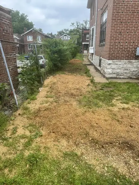Smooth ground in a side yard between houses after stump grinding