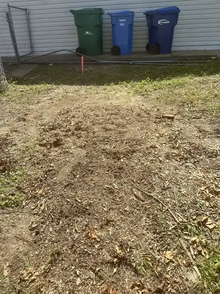 Ground-out area near trash bins after stump grinding