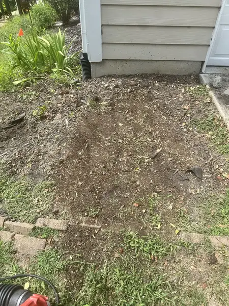 Ground-out bed beside house siding