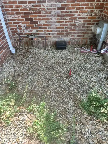 Gravel and chips by a brick wall after stump grinding