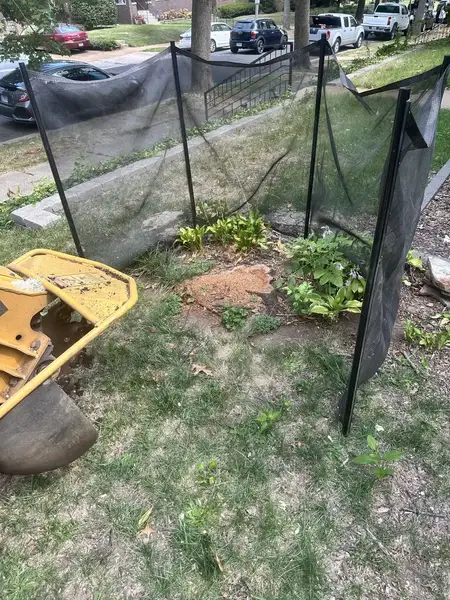 Stump grinder behind a safety screen near the street